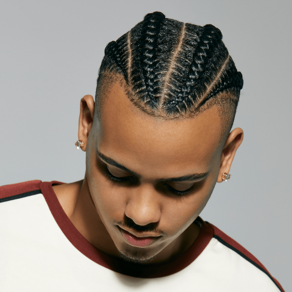 A man showing off his shiny braids after using Braid Sheen Refresher from KISS Colors and Care.