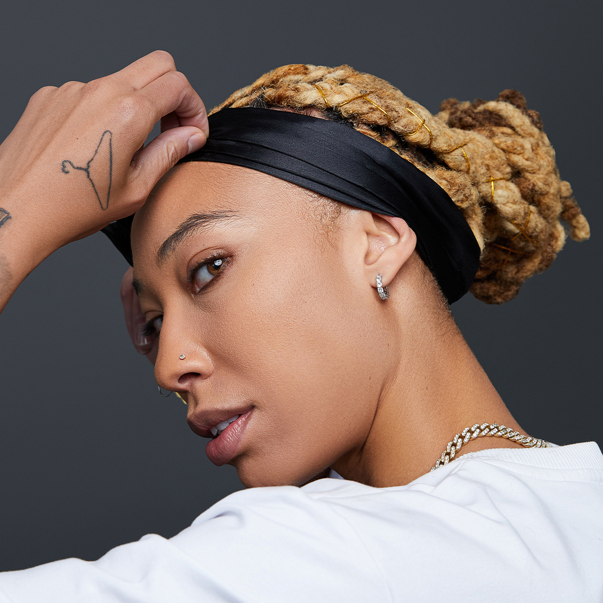 A woman looking stylish while laying her edges with a black, premium satin edge scarf from KISS Colors & Care.