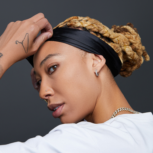 A woman looking stylish while laying her edges with a black, premium satin edge scarf from KISS Colors &amp; Care.