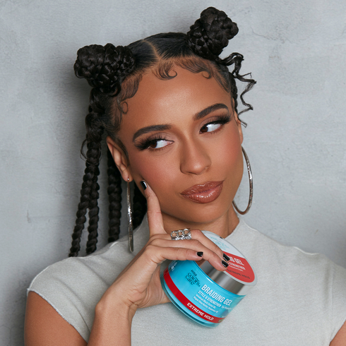 A woman with shiny, soft-looking braids, holding a container of KISS Colors &amp; Care Braiding Gel in Extreme Hold.