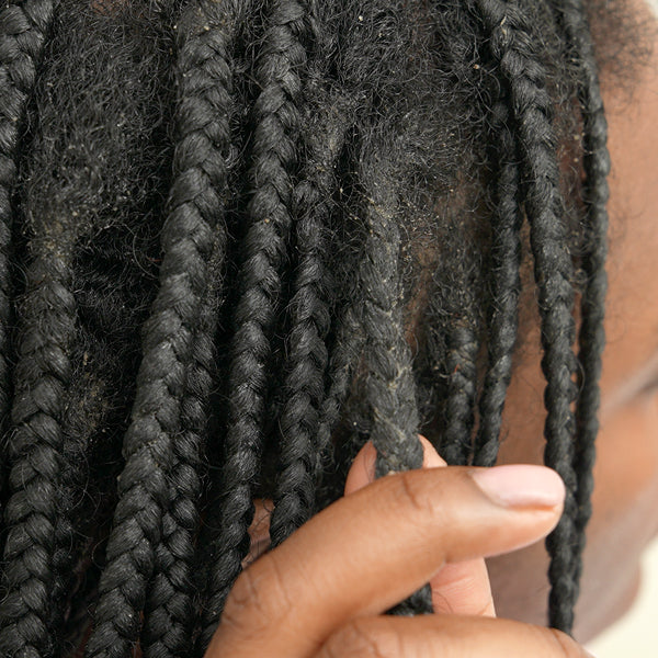 Close-up of braided hair with a hand touching it