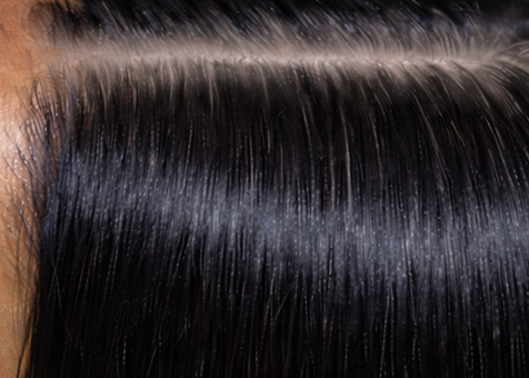 Close-up of shiny, smooth, and straight black hair strands with a healthy, glossy finish under natural light.