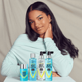 Young woman with long, shiny black hair wearing a light blue top poses behind four KISS Colors &amp; Care heat protector hair products in blue packaging, labeled for coarse to thin hair.